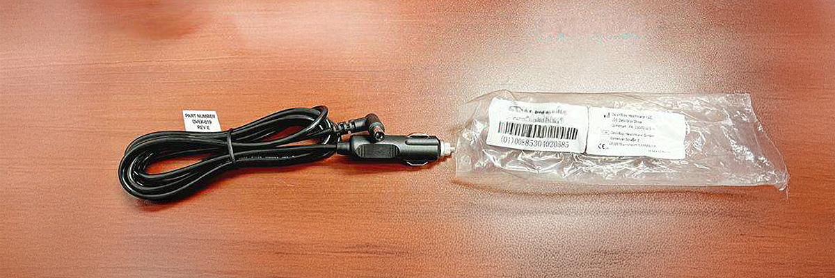 Imagen del dispositivo afectado en la que se muestra localización de la  etiqueta en el cable de alimentación y el número de lote en la bolsa que lo contiene